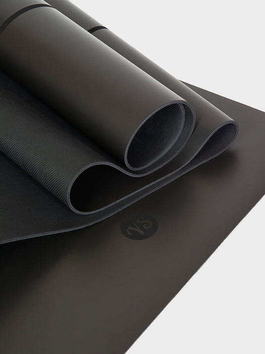 Black yoga mat with a brand logo on a light gray background