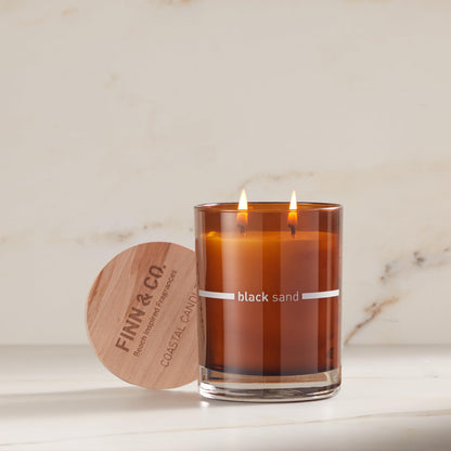 FINN & CO. Vela Arena Negra – Cera de Soja de 9.5 oz, Frasco Ámbar, Aroma Inspirado en la Playa