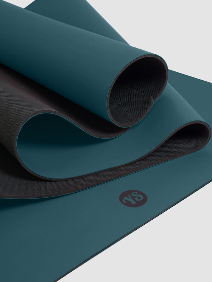 Teal yoga mat with a logo on a light gray background