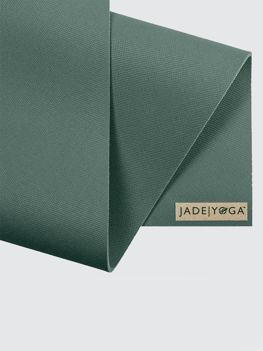 Green yoga mat with 'Jade Yoga' logo on a light gray background